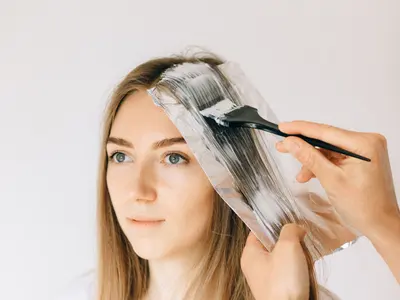 Highlights being painted onto a foil during a colour appointment
