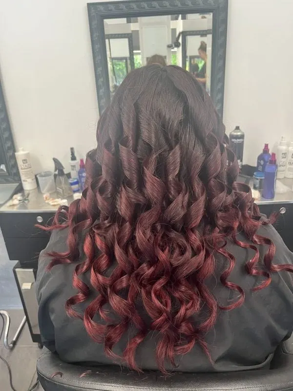 Dark to burgundy ombre with tonged curls by Harvey's Hairdressers, Luton